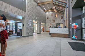 Welcome to our lobby, featuring a spacious reception area with a large desk, comfortable seating, and a large window.