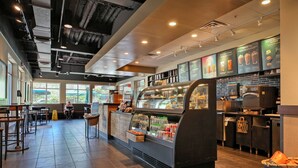 A modern coffee shop interior with a counter, seating area, and menu boards. - Beautiful Resort! Cozy, 2 Room Junior Suite! (Myrtle Beach)