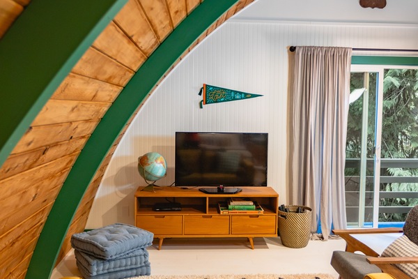 Relax in the upstairs loft, featuring a smart TV, DVD player, and comfy seating