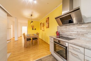 Una cocina moderna con horno empotrado, microondas y campana extractora de acero inoxidable.