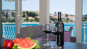 A table with a bottle of wine, two wine glasses, and a plate with watermelon and grapes. - LUXURY 2 BEDROOMS, 2 BATHROOMS APARTMENT WITH WHIRLPOOL AND SAUNA (Trogir)