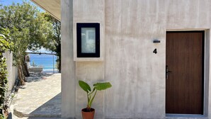 Un edificio con fachada de hormigón, una planta en maceta, un cuadro enmarcado y una puerta con el número 4.