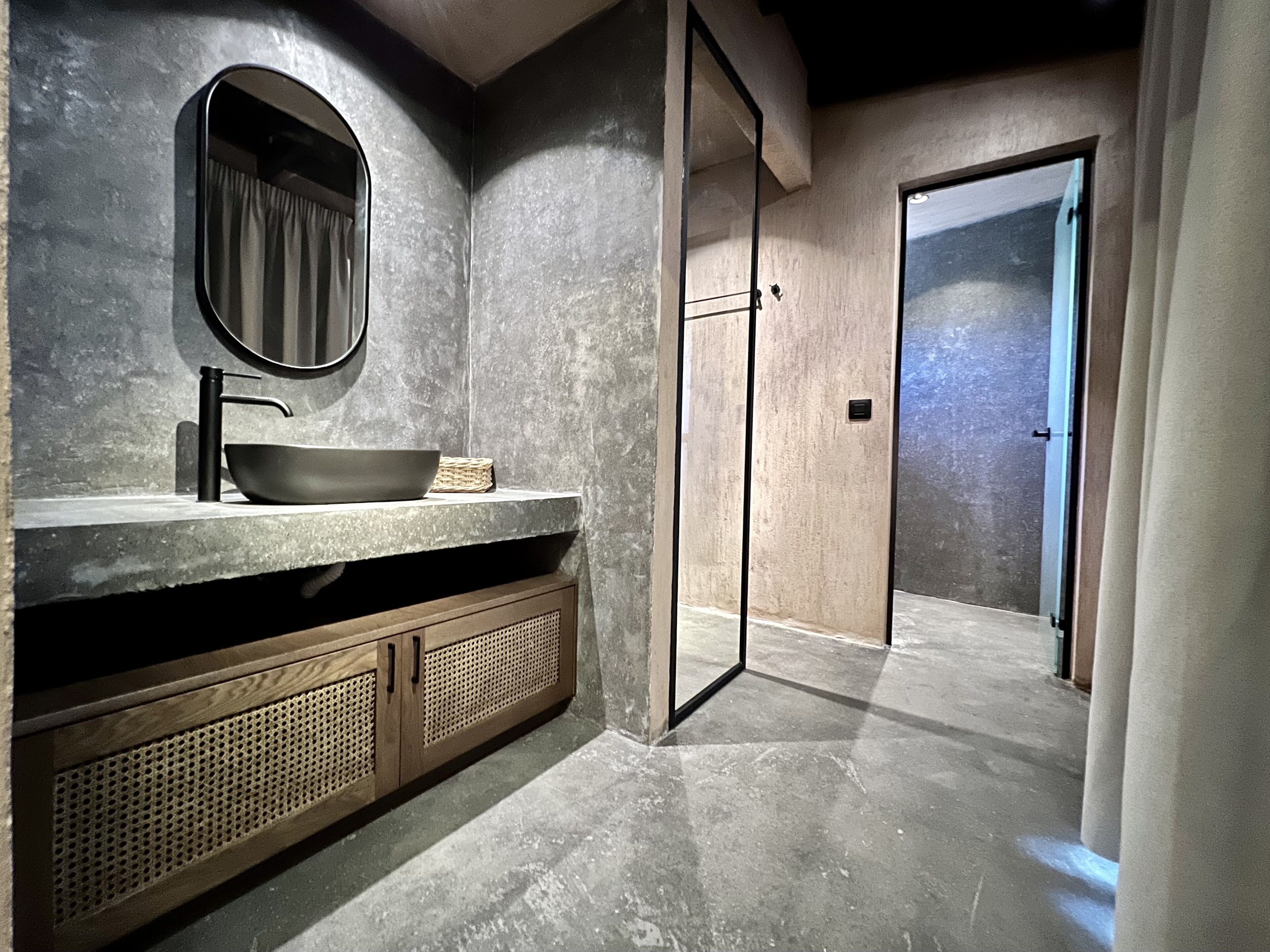 Ein modernes Badezimmer mit einem großen Spiegel, einem Waschbecken und einer begehbaren Dusche.