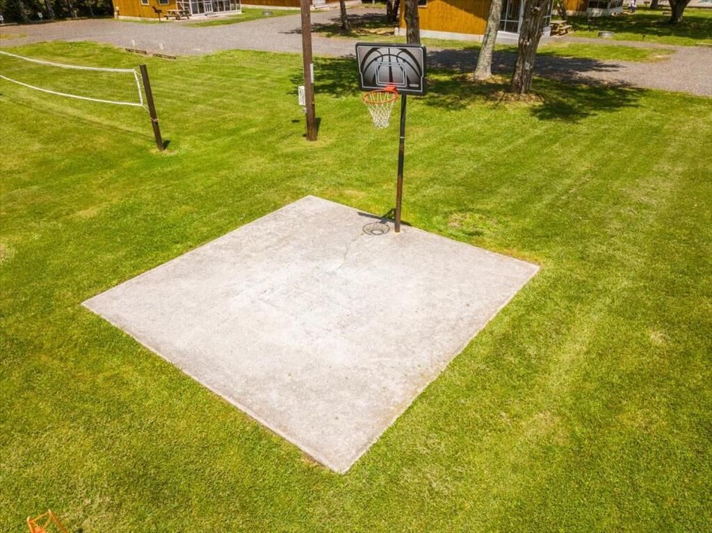 Un terrain de basket-ball avec un panier et une zone carrée en béton.