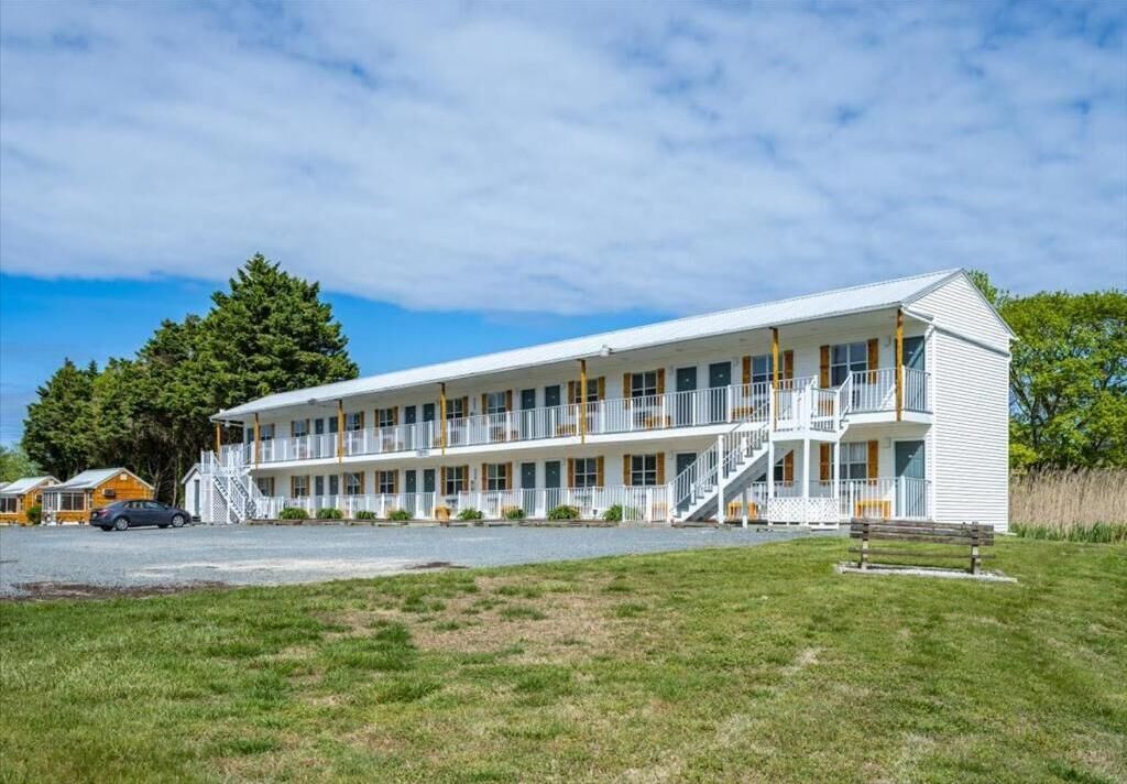 A two-story motel with a central corridor and individual rooms on either side.