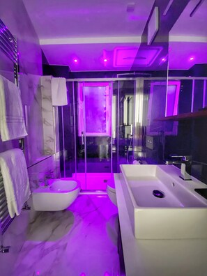 A modern bathroom with a glass shower enclosure, a white sink, and a marble floor. - BorgiaRooms (Milazzo)