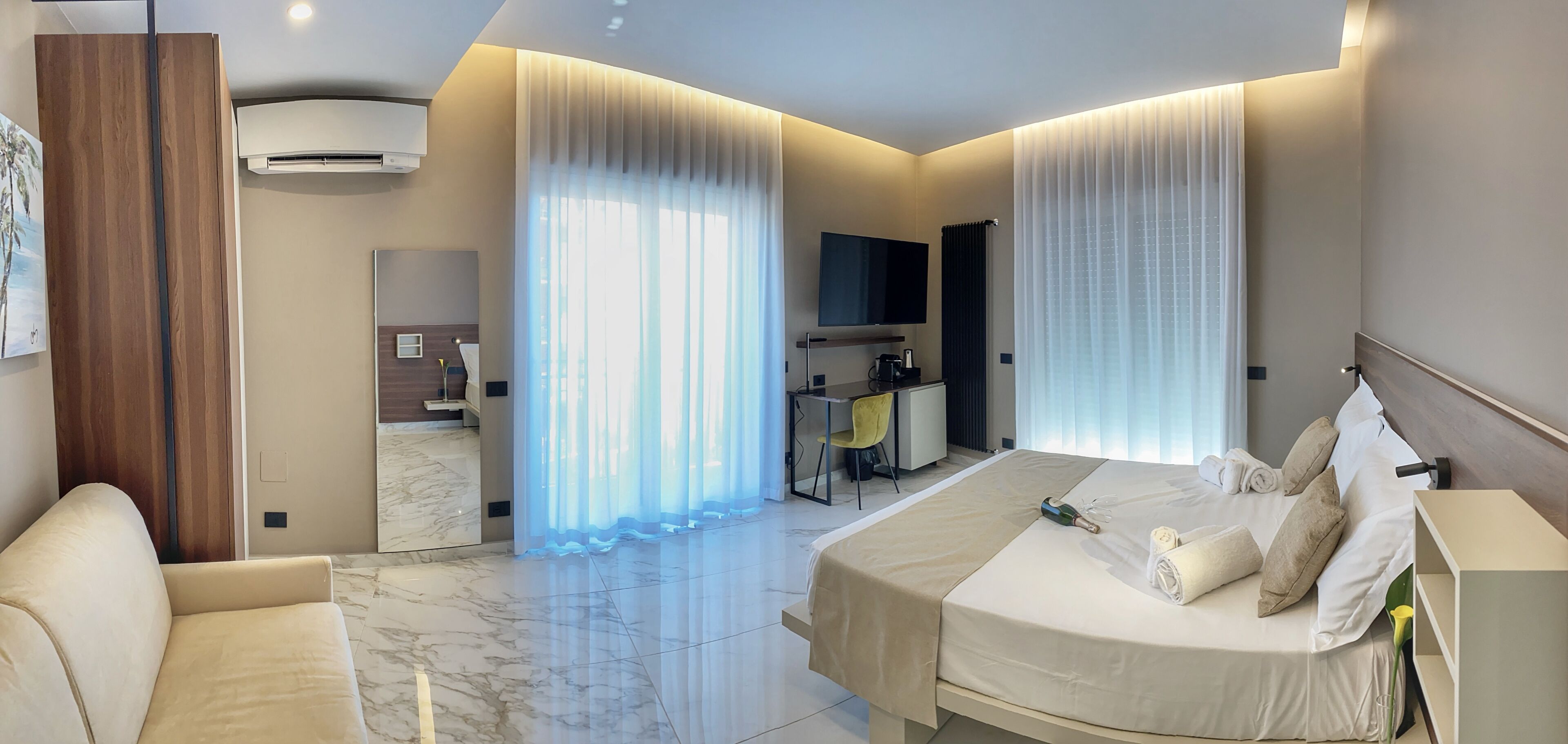 Ein modernes Hotelzimmer mit einem großen Bett, einem Schreibtisch und einer Sitzecke.