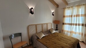 A bedroom with a bed, a chair, a nightstand, and a lamp. - Sheepfold in dry stones with outdoor spa, calm assured  (Granace)