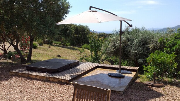 An outdoor patio with a wooden table, a bench, and a patio heater. - Sheepfold in dry stones with outdoor spa, calm assured  (Granace)