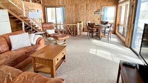 Ein Holzinterieur mit einer Ledersofa, einem Holztisch und einem Essbereich.