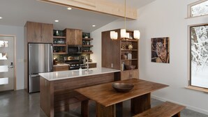 A modern kitchen with wooden cabinets, stainless steel appliances, and a central island.