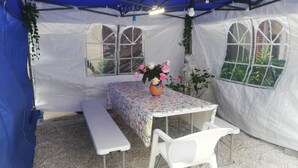 A tent with a table and benches, covered with a floral tablecloth, and a vase with flowers. - APPALOOSA' (ministerial classification) quiet T2 apartment Tarbes near downtown  (Tarbes)