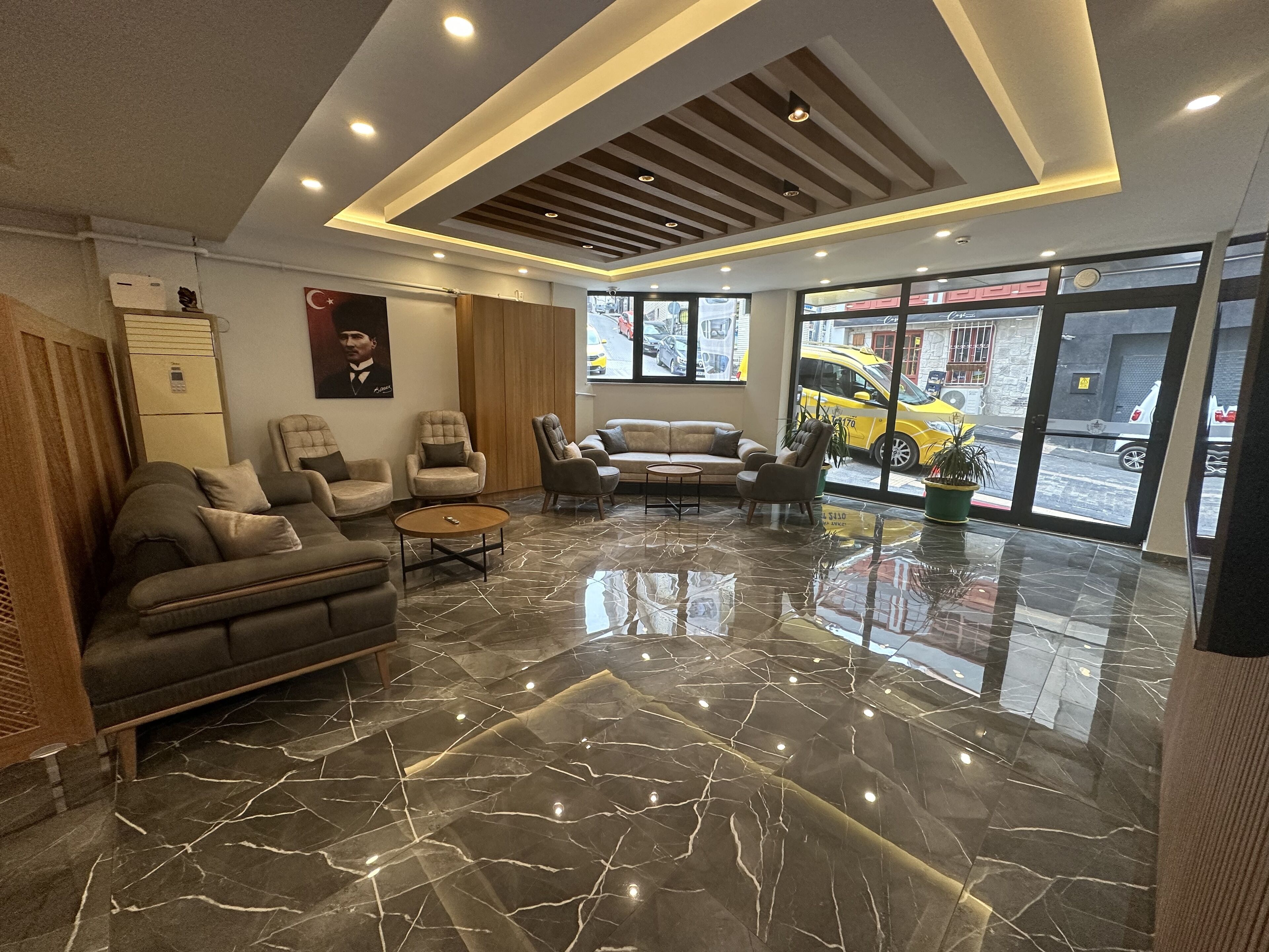 A modern lobby with a marble floor, leather sofas, and armchairs.