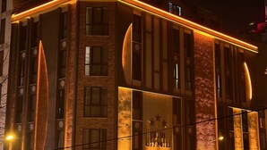Un edificio moderno con un diseño arquitectónico único, con líneas curvas y ventanas iluminadas.