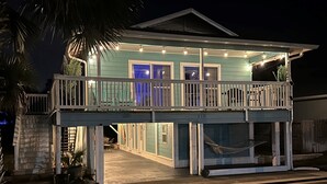A two-story house with a balcony, a hammock, and string lights. - Salt and Sand Studio (Downstairs Only) (Panama City Beach)