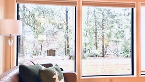 Una habitació amb un finestral gran, un sofà de cuir i una làmpada.