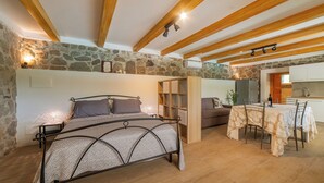 Een slaapkamer met een bed, nachtkastjes en een houten plafond.