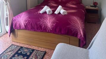 Een slaapkamer met een bed, nachtkastje, lamp, schilderij en wanddecoratie.