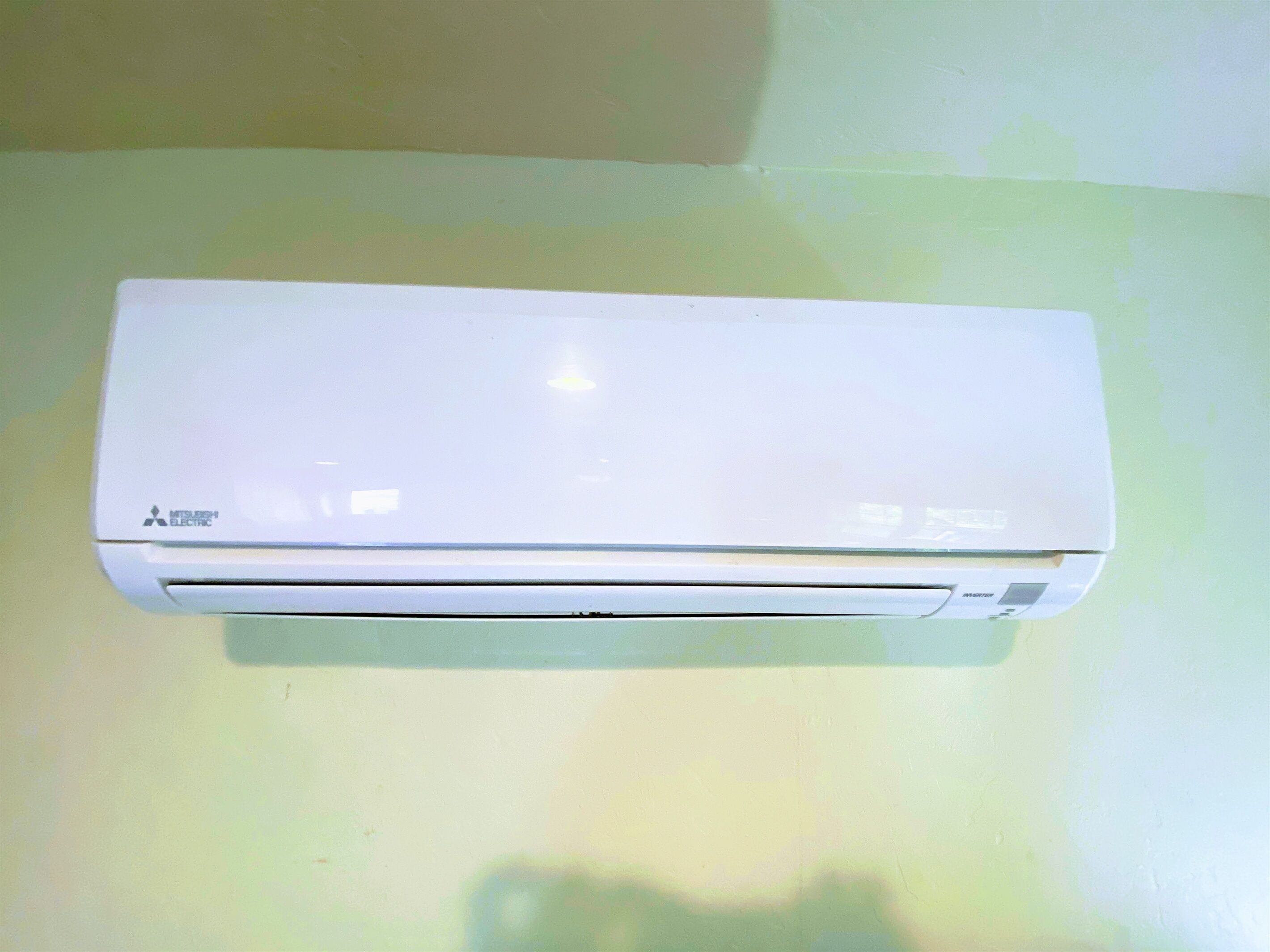 Eine weiße Mitsubishi Klimaanlage an der Wand befestigt.