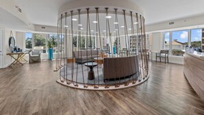Een ruime lobby met een centraal zitgedeelte, grote ramen en een modern design.