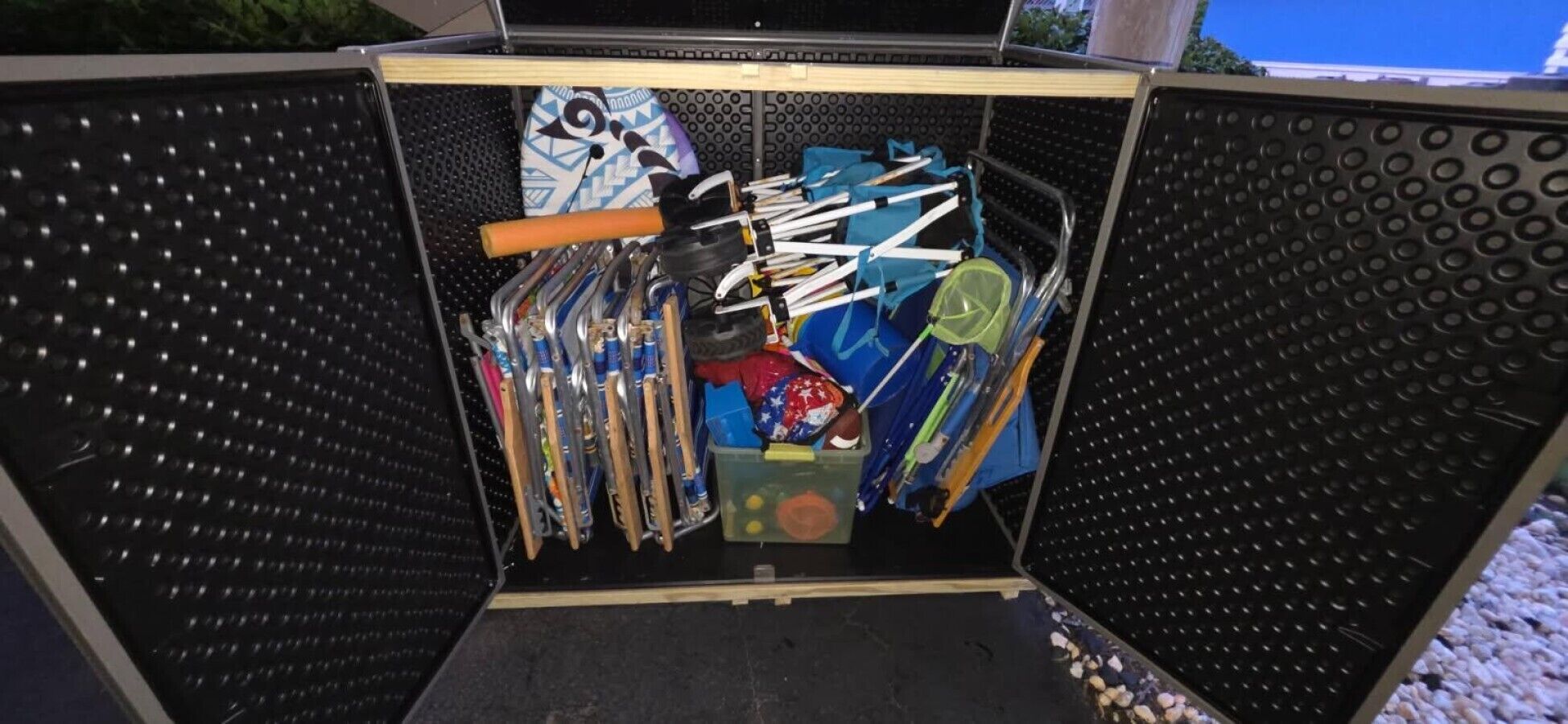 Un espace de rangement contenant divers objets, notamment une batte de baseball, un casque et du matériel de sport.