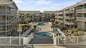 A multi-story hotel with a central courtyard featuring two swimming pools and a small circular pool. - 3rd Floor Ocean View, Pools/Hot Tub- Shore Dr (Myrtle Beach)