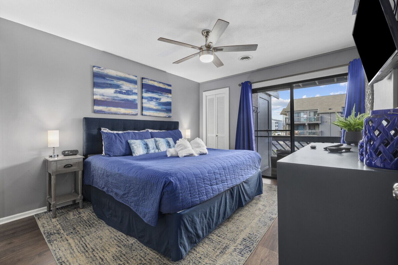 A bedroom with a bed, bedside table, and a ceiling fan.