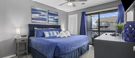 A bedroom with a bed, bedside table, and a ceiling fan.