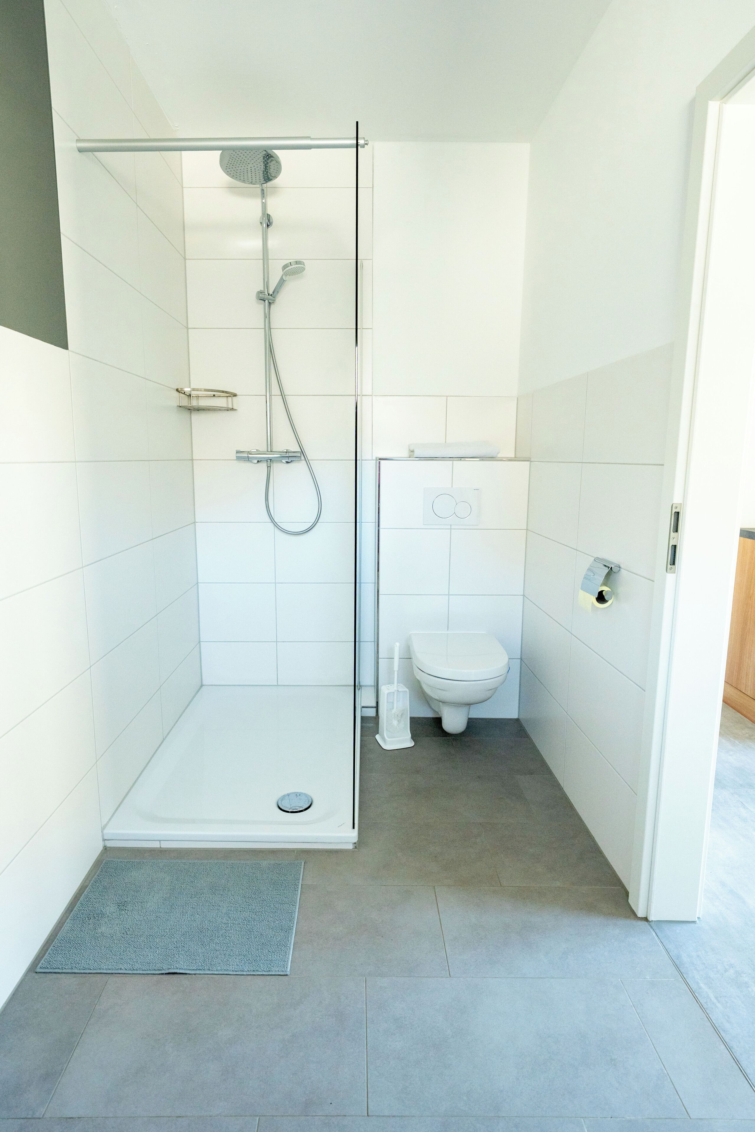 Un baño moderno con ducha de vidrio, inodoro y bidé.