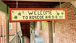 Un letrero da la bienvenida a visitantes a Roscoe Air B&B, fundado alrededor de 1856.