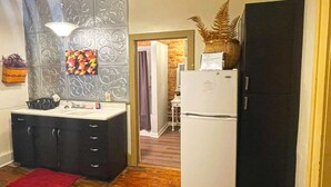 Una cocina compacta con refrigerador, lavamanos y encimera.