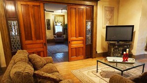 A living room with a sofa, a glass coffee table, and a television. - Pearl`s Place in heart of Historic Roscoe Village (Coshocton)