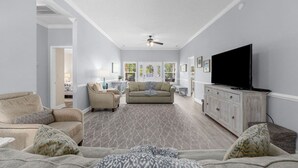 A living room with a sofa set, a television, and a ceiling fan. - Pet-friendly Home w/ Pool, Hot Tub and Golf Cart (North Myrtle Beach)