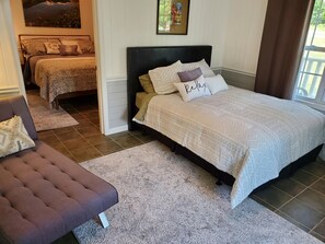 Relax in comfort with a large bed, sofa, and artwork in a stylishly appointed room.