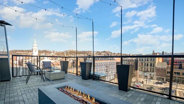 A rooftop terrace with a fire pit, seating area, and a view of the cityscape. - The Penthouse- Heart of OTR w/Rooftop Terrace (Cincinnati)