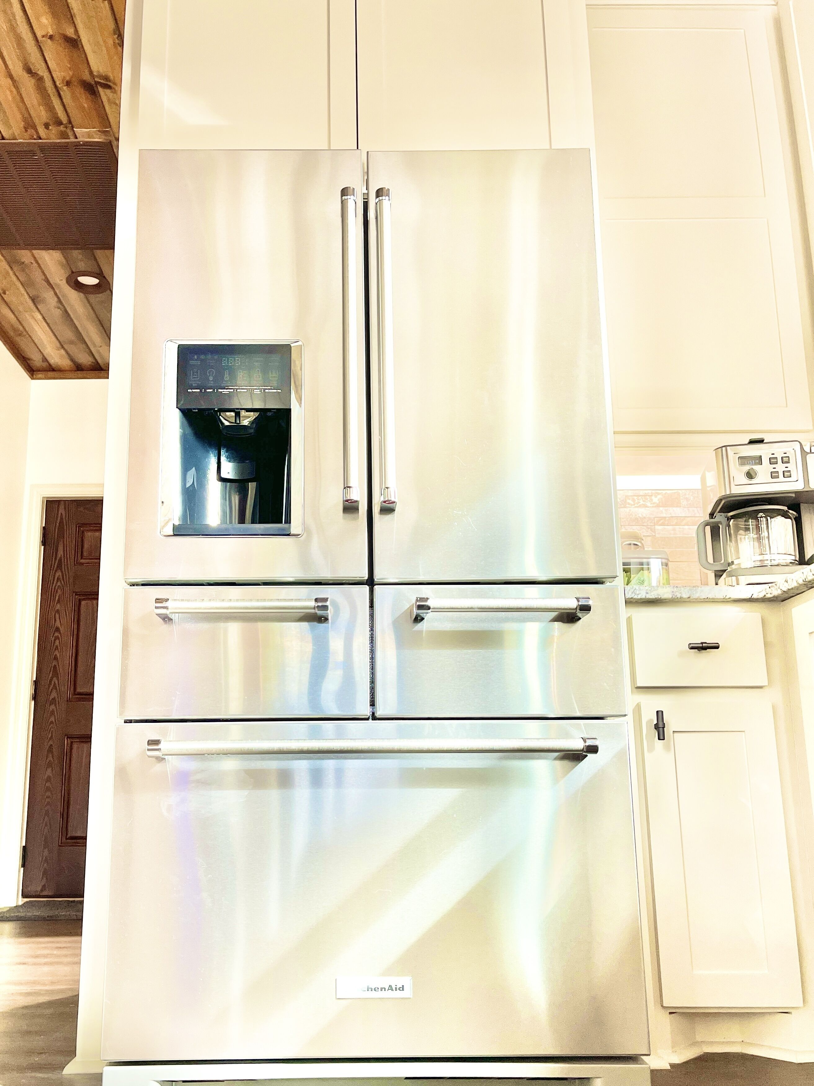A stainless steel double-door refrigerator with a water dispenser, a built-in ice maker, and a freezer compartment.