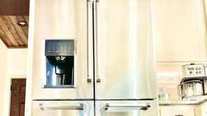 Ein Edelstahl-Kühlschrank mit Wasserspender, integriertem Eiswürfelbereiter und einem separaten Gefrierfach.