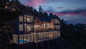 Ein zweigeschossiges Haus mit Balkon, großen Fenstern und einem Pool.