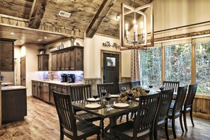 A dining area with a wooden table set for four, surrounded by dark wooden chairs. - AMAZING Luxury Cabin! Stunning Views! Fire Pits! Playground! Theater! Game Room! (Gatlinburg)