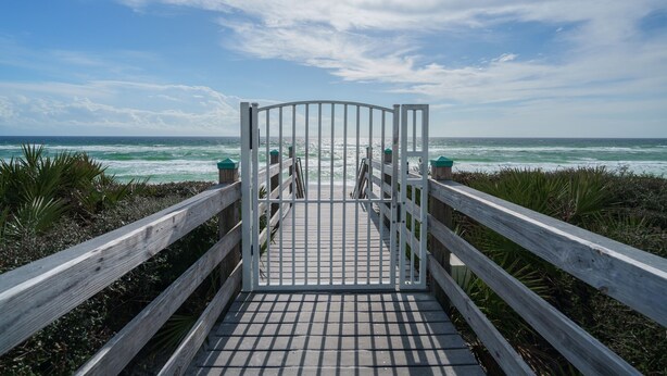 A wooden boardwalk leading to a gated entrance with a view of the ocean. - Romantic getaway Luxe 30A Beach, 2 Free Bikes right between Alys Beach &Rosemary (Panama City Beach)