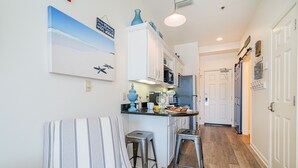 A kitchen with white cabinets, a striped chair, and two stools. - Romantic getaway Luxe 30A Beach, 2 Free Bikes right between Alys Beach &Rosemary (Panama City Beach)