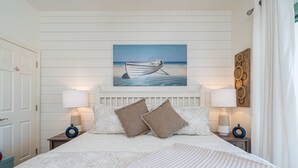 A bedroom with a large bed, two nightstands, a painting of a boat on the wall, and a view of the sea. - Romantic getaway Luxe 30A Beach, 2 Free Bikes right between Alys Beach &Rosemary (Panama City Beach)