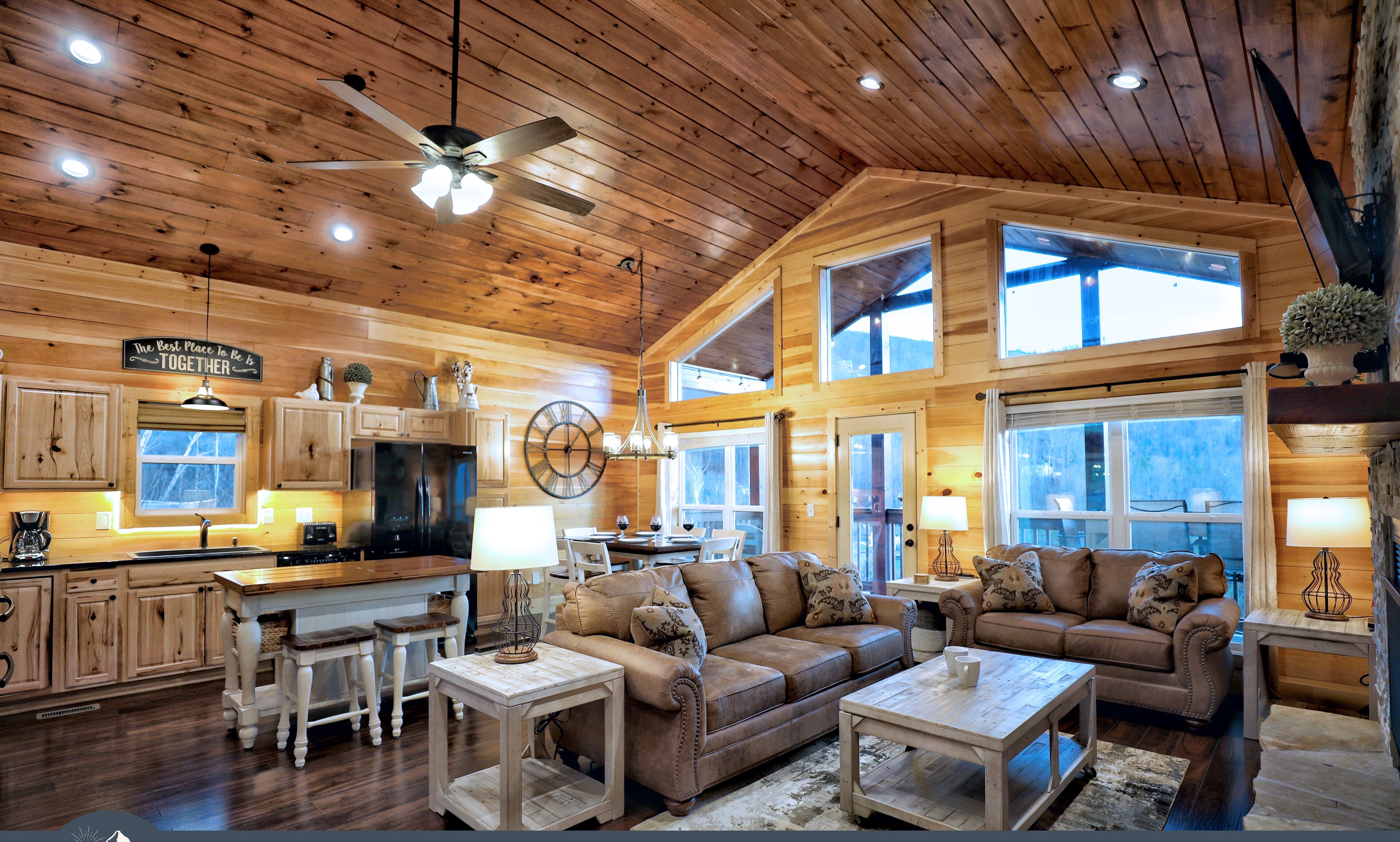 A spacious log cabin interior with a kitchen, dining area, and living room.