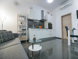 A modern kitchen with white cabinets, a built-in oven, and a stainless steel range hood. - Apartment Toni - Two Bedroom Apartment with Terrace and Shared Swimming Pool (Nin)