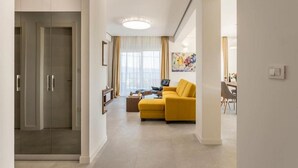 A modern living room with a sofa, a coffee table, and a TV. There is a door leading to another room. - Villa Grey - Three Bedroom Villa with Swimming pool (Kastel Kambelovac)