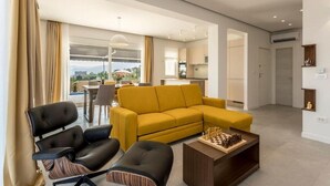 A modern living room with a yellow sofa, a black leather chair, and a wooden coffee table with chess pieces. - Villa Grey - Three Bedroom Villa with Swimming pool (Kastel Kambelovac)