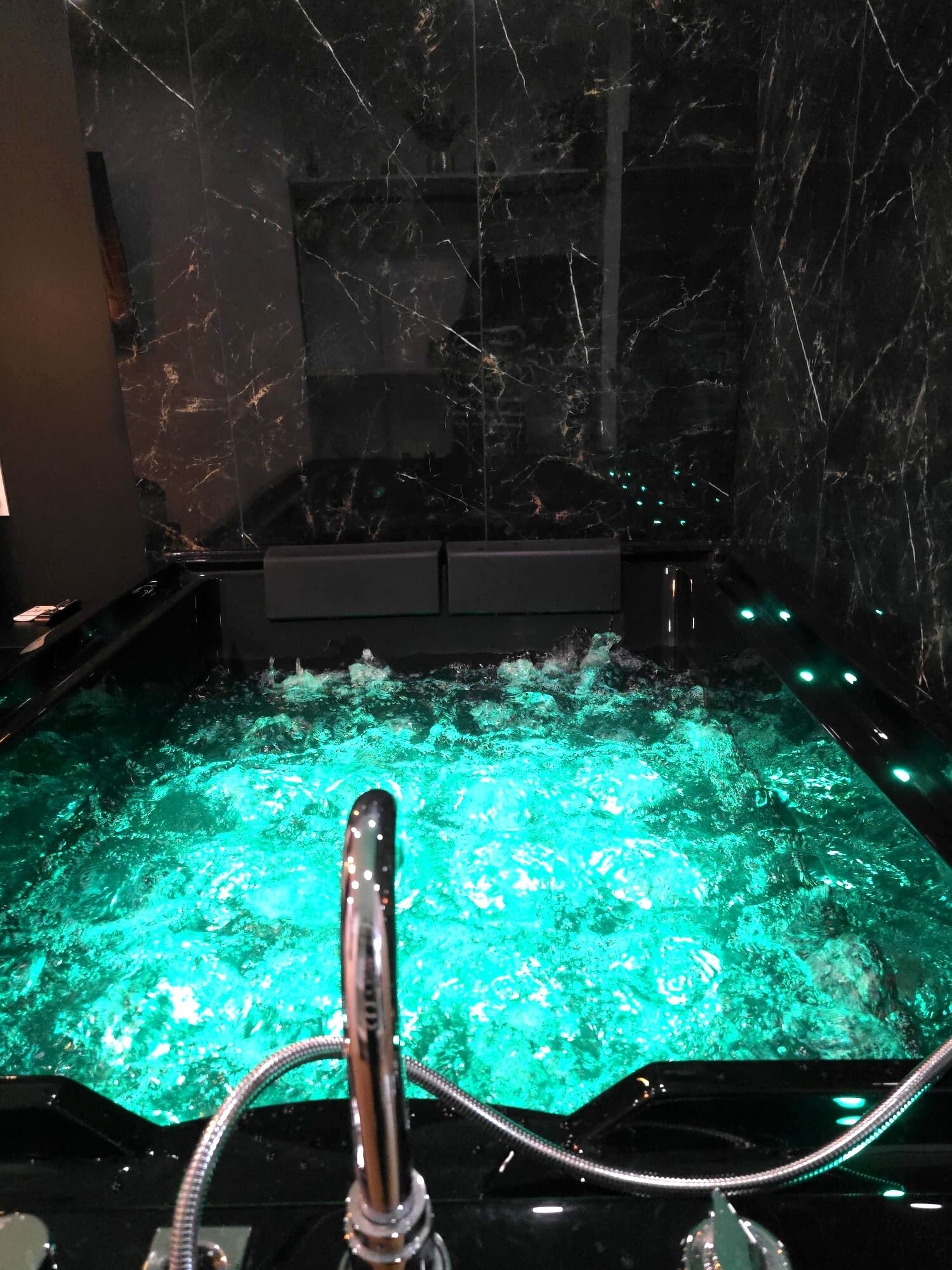 A hot tub with a marble interior and a visible water pump.