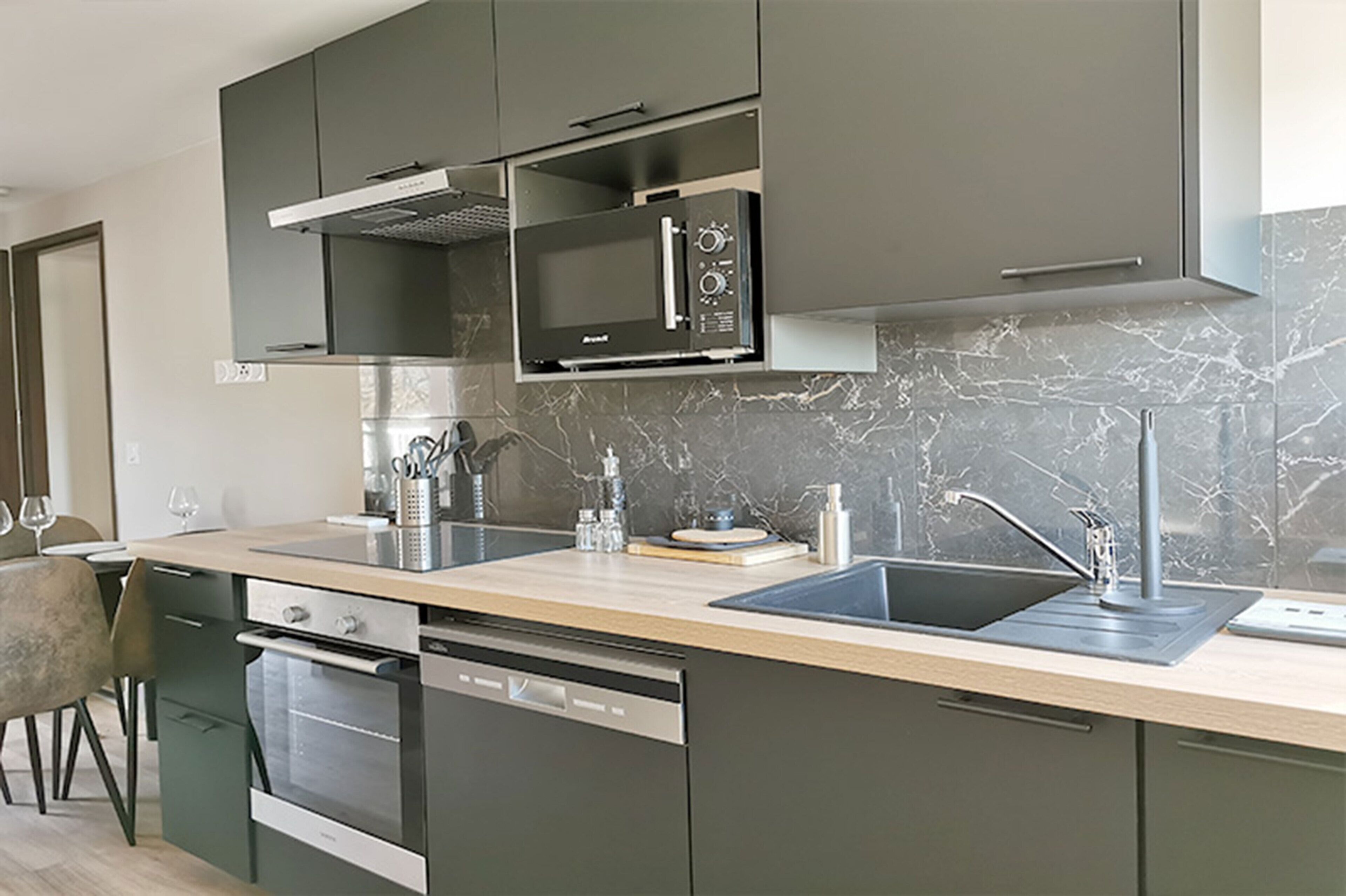 Una cucina moderna con elettrodomestici integrati, lavastoviglie e lavello.
