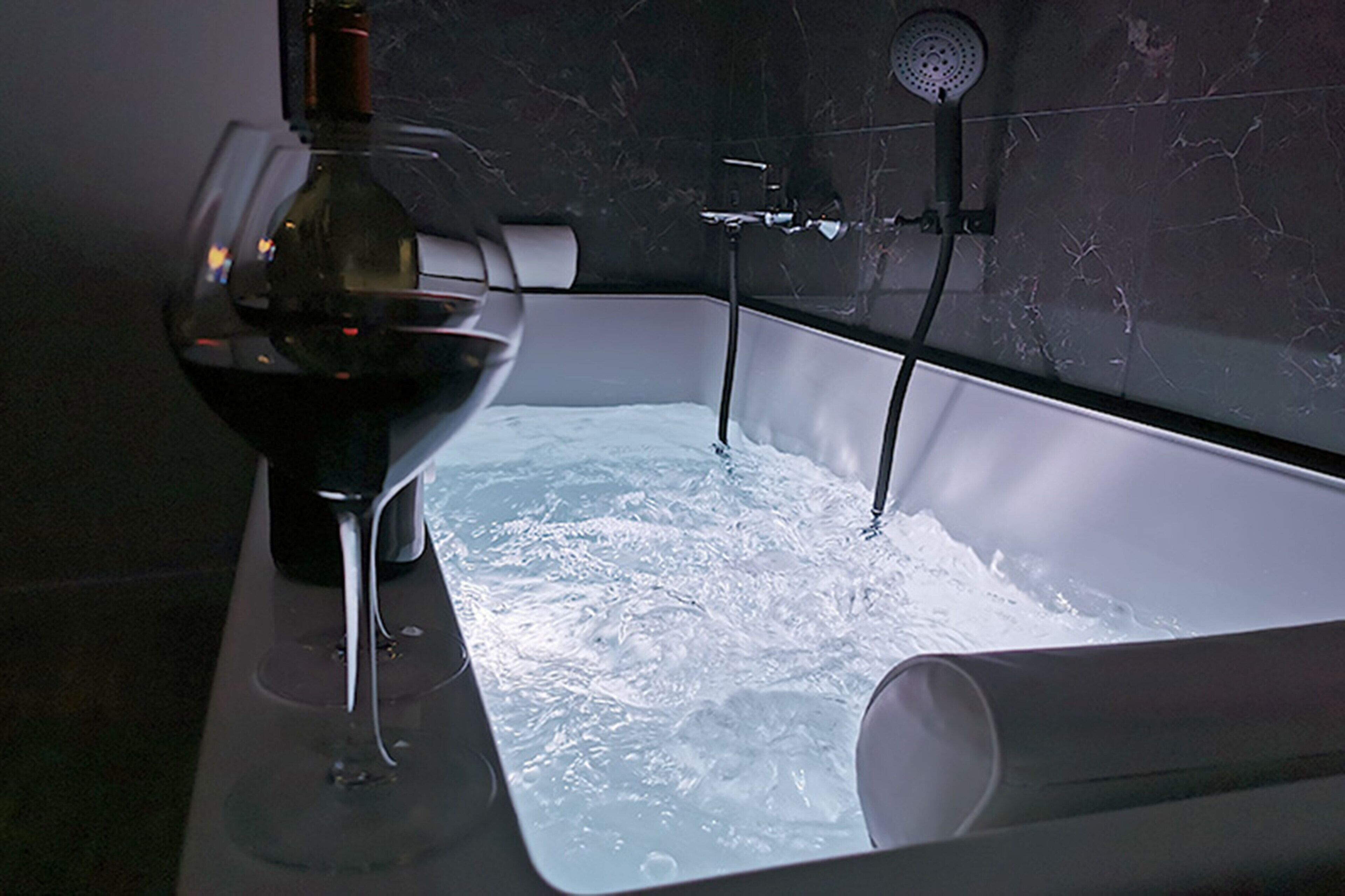 A bathtub with a glass enclosure and a showerhead.