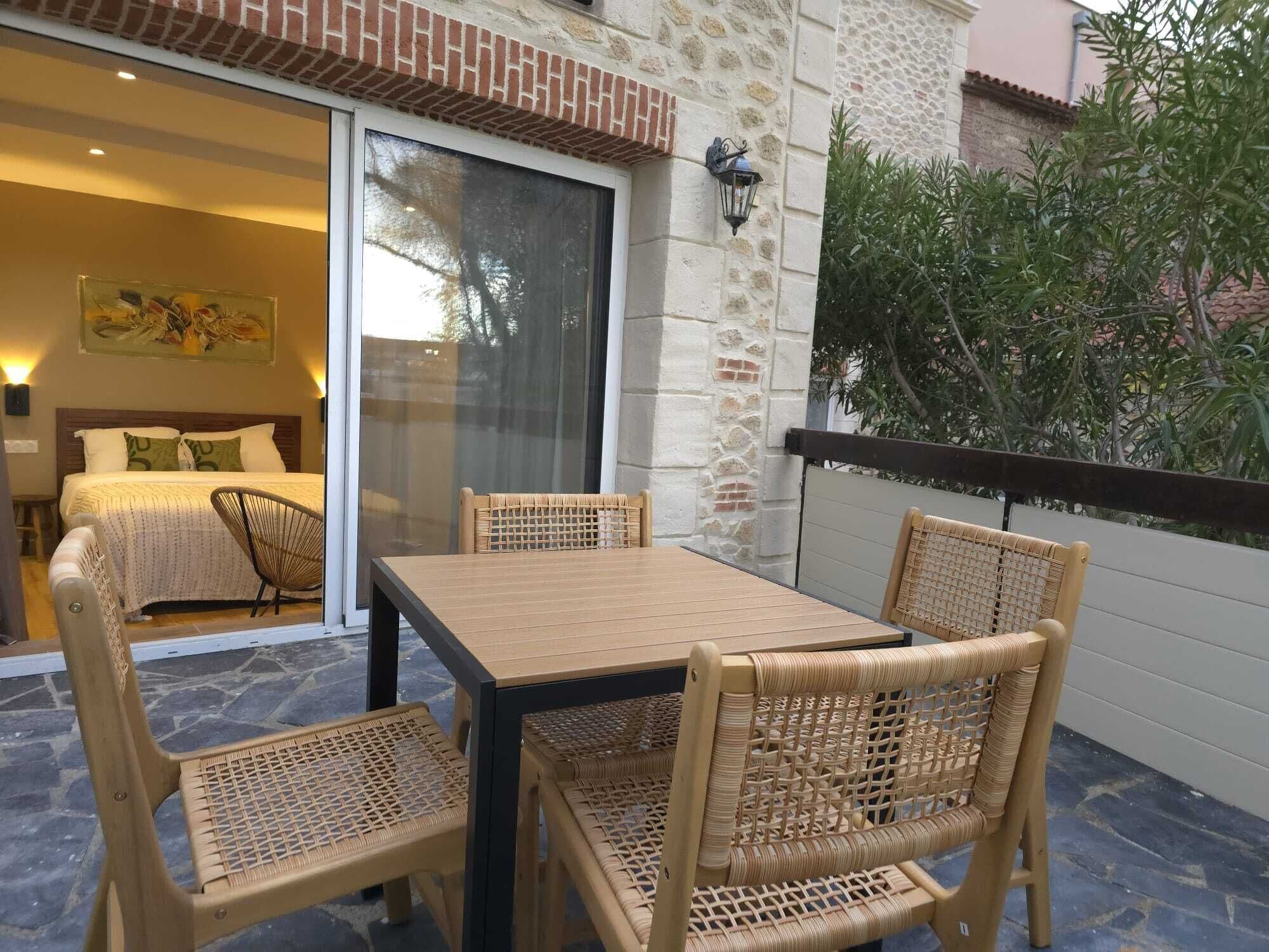 Ein Balkon mit Korbmöbeln, ein Bett mit Blick und eine Steinwand.